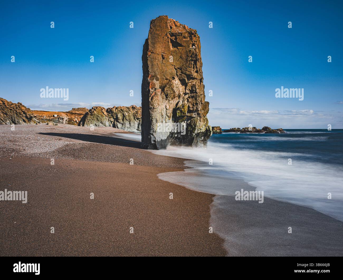 Meeresstapel an einem schwarzen Sandstrand in der Nähe von Stapavík, Ost-Island, mit weichem, langanhaltendem Wasser Stockfoto
