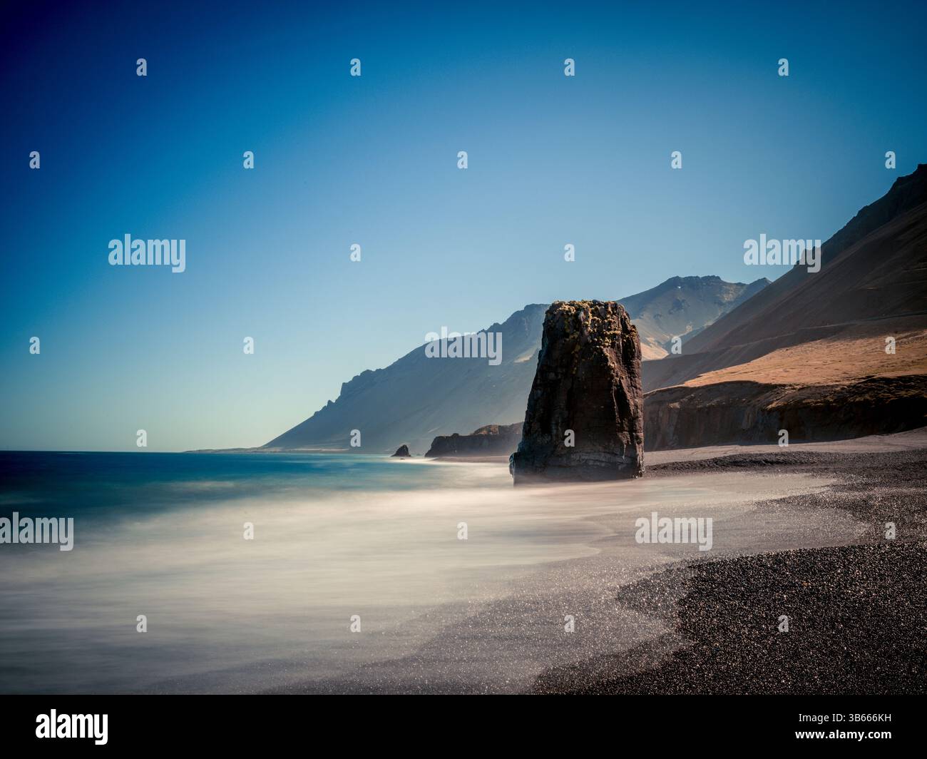 Meeresstapel an einem schwarzen Sandstrand in der Nähe von Stapavík, Ost-Island, mit weichem, langanhaltendem Wasser Stockfoto