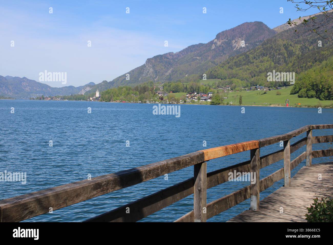 Panoramaweg entlang des Ufers des Wolfgangsees in Strobl. Blick auf den Wolfgangsee und die umliegenden Berge. Österreich, Europa. Stockfoto