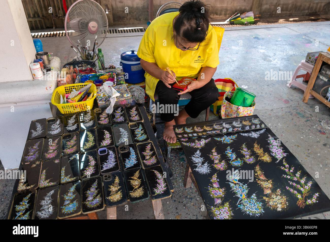 Ein Künstler, der eine Handyhülle im Dorf Bo Sang Umbrella in Chiang Mai, Thailand, malte Stockfoto