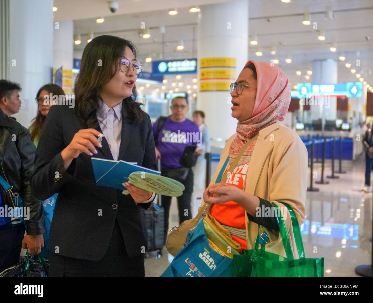 (250503) -- PEKING, 3. Mai 2025 (Xinhua) -- Ein Mitarbeiter der Tianjin Niederlassung der Bank of China (BOC) stellt indonesischen Touristen Fabiona am 1. Mai 2025 einen Leitfaden für Zahlungsdienste im Tianjin International Cruise Home Port in Tianjin, Nordchina, zur Verfügung. China hat am 27. April ein neues Maßnahmenpaket zur weiteren Optimierung der Politik zur Erstattung der Abreisesteuer und zur Steigerung der Ausgaben für eingehende Reisen eingeführt. Zu den Maßnahmen, die vom Handelsministerium und fünf anderen Regierungsstellen angekündigt wurden, gehören eine Senkung der Mindestbeschwelle für Erstattungen, eine Anhebung der Obergrenze für die Barrückerstattung und eine Ausweitung der Obergrenze Stockfoto