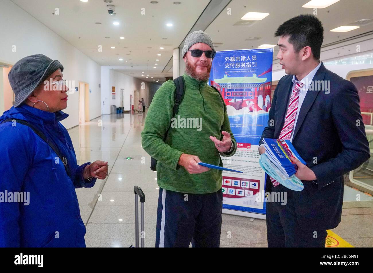 (250503) -- PEKING, 3. Mai 2025 (Xinhua) -- Ein Mitarbeiter der Tianjin-Niederlassung der Bank of China (BOC) bietet dem neuseeländischen Touristen Jason am 1. Mai 2025 einen Leitfaden für Zahlungsdienste im Tianjin International Cruise Home Port in Tianjin, Nordchina. China hat am 27. April ein neues Maßnahmenpaket zur weiteren Optimierung der Politik zur Erstattung der Abreisesteuer und zur Steigerung der Ausgaben für eingehende Reisen eingeführt. Zu den Maßnahmen, die vom Handelsministerium und fünf anderen Regierungsstellen angekündigt wurden, gehören die Senkung der Mindestbeschaffungsschwelle für Erstattungen, die Anhebung der Obergrenze für Barrückerstattungen und die Ausweitung der Stockfoto