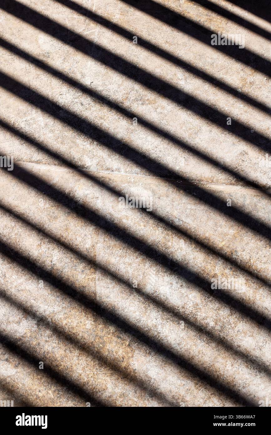 Komplexe Schatten auf einer strukturierten Oberfläche erzeugen ein ansprechendes abstraktes Design, das den Betrachter in seinen Bann zieht Stockfoto