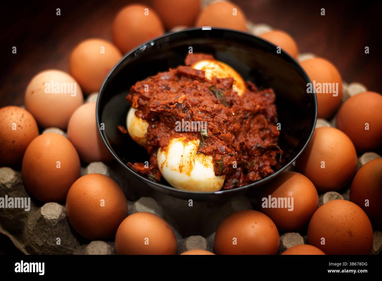 Nahaufnahme Von Egg Curry In Black Pot. Hintergrund Gefüllt Mit Frischen Eiern Stockfoto