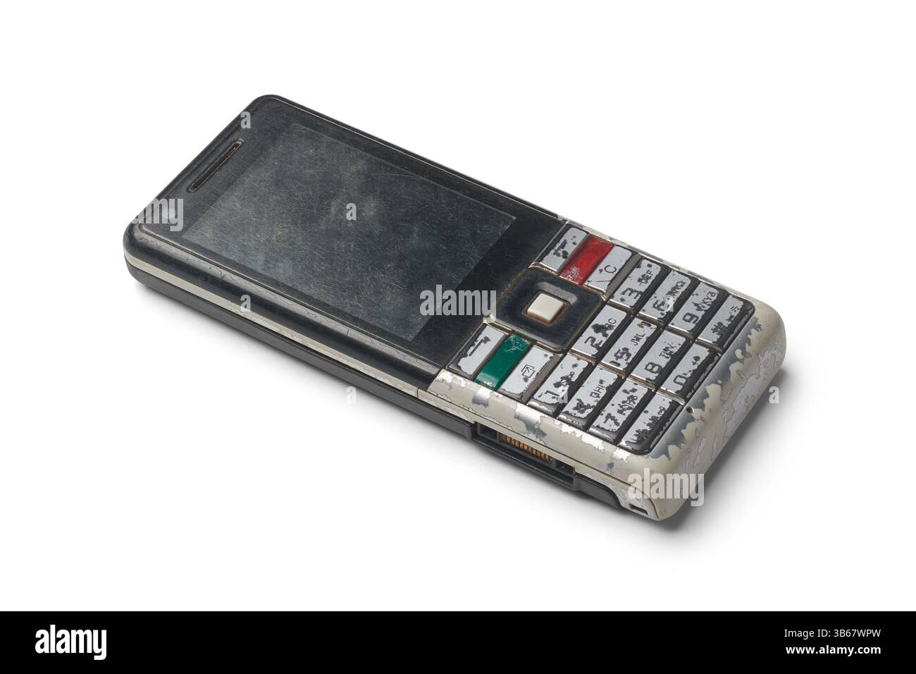 Altes veraltetes Mobiltelefon isolierter weißer Hintergrund, Handapparat der vergangenen Generation mit abgenutzter physischer Tastatur und verkratztem Kunststoff Stockfoto