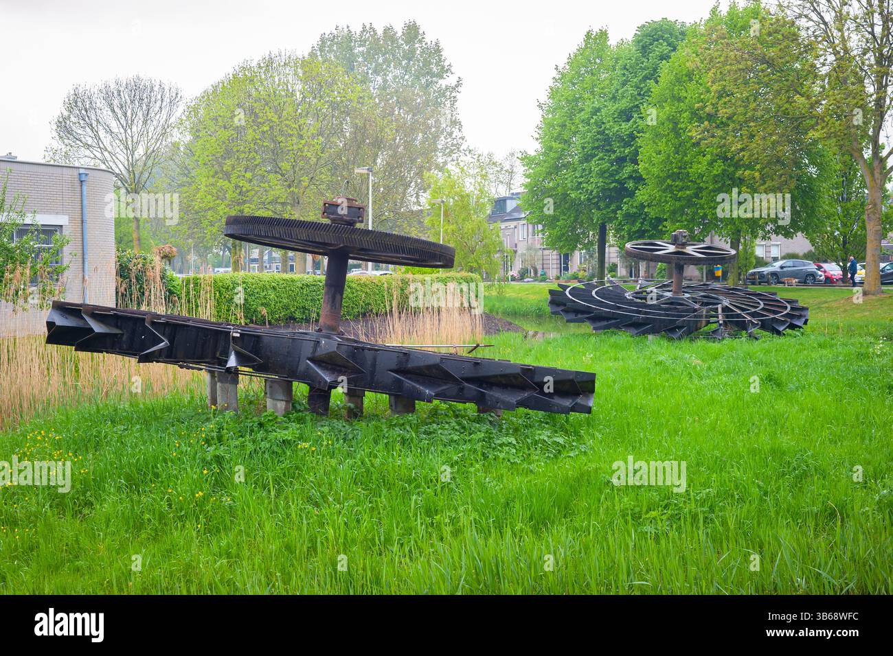 Kunstwerk für den niedrigsten Wasserstand, bestehend aus Schaufelrädern aus einer Pumpstation. Der Name der Arbeit ist "der vergessene Ort. Waddinxveen, Niederlande. Stockfoto