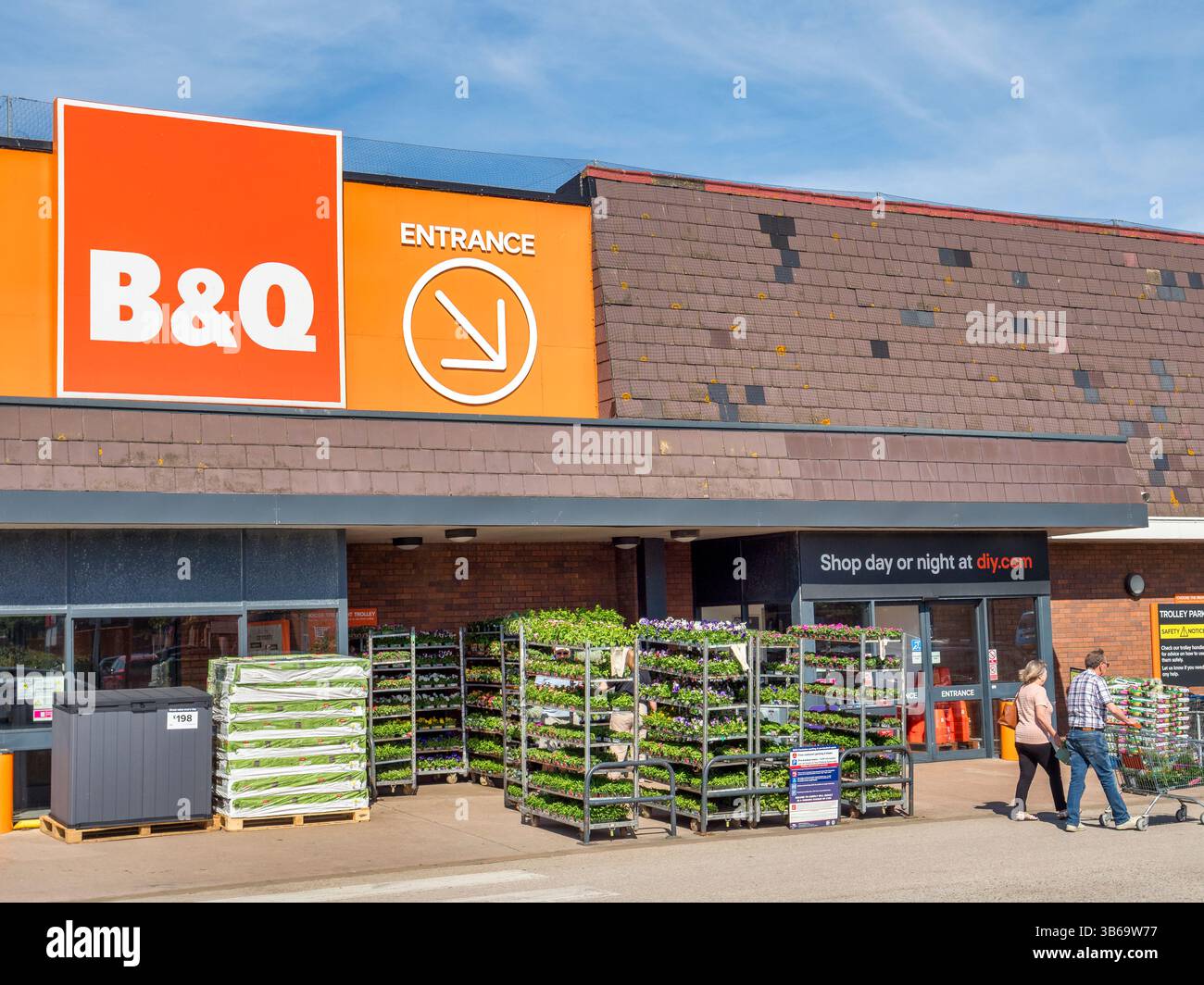 B&Q Heimwerkergeschäft, Llandudno, North Wales, UK, mit Menschen, Pflanzen zum Verkauf, Vordereingang. Stockfoto