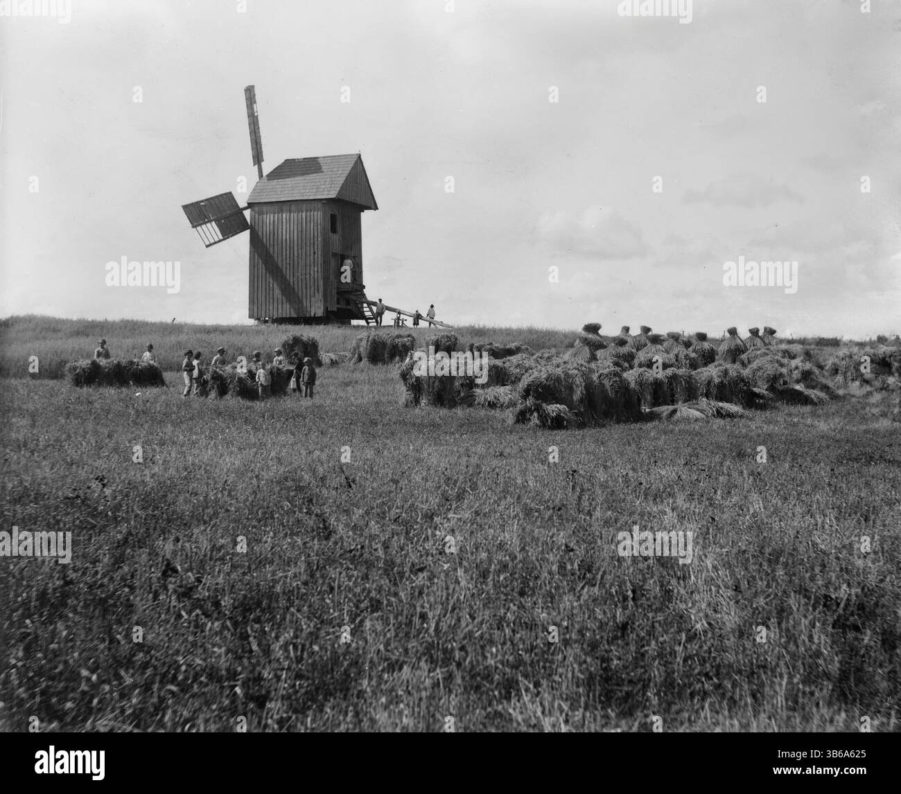 Ländliche Szene eines landwirtschaftlichen Feldes mit Windmühle, Polen, um 1919. Stockfoto