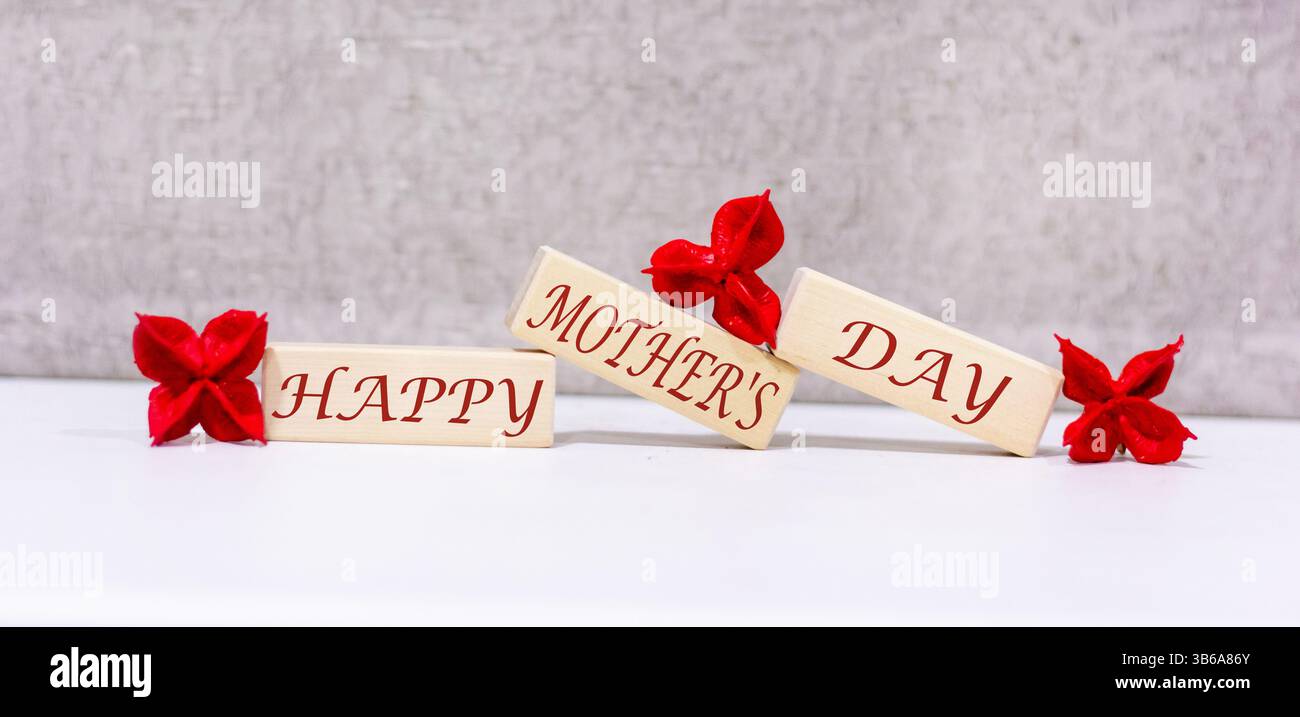 Happy Mother's Day steht auf drei Holzblöcken. Wunderschöner Hintergrund Stockfoto