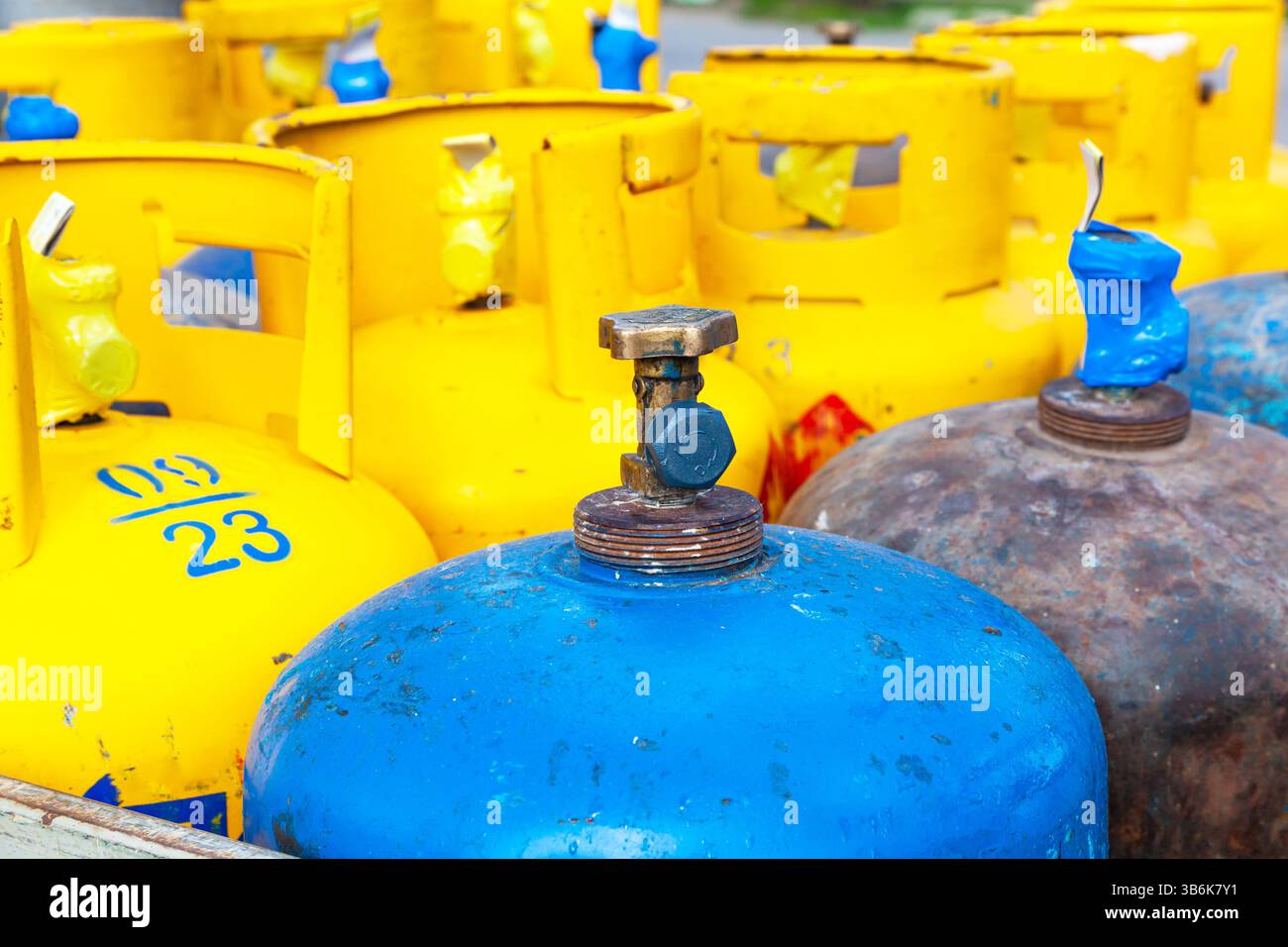 Blaue und gelbe Gasflaschen aus nächster Nähe. Stockfoto
