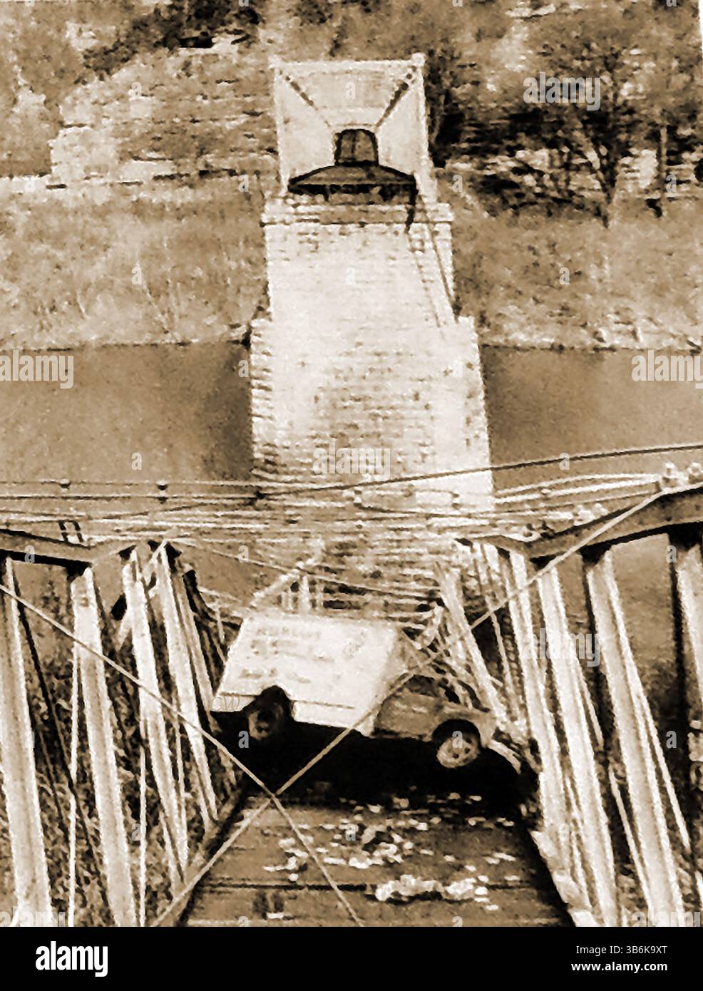 1953 – Zusammenbruch der 82 Jahre alten Brooklyn Bridge über den Kentucky River bei Harrodsburg, Kentucky. Er brach unter dem Gewicht eines Food Service Trucks zusammen. Die Brücke war 1871 gebaut worden, um Cogar’s Ferry zu ersetzen, aber sie war kontinuierlich geschwächt. Sie wurde 1956 abgerissen und ersetzt. Der Lkw-Fahrer brach sich den Rücken und verklagte den Staat wegen der unsicheren Brücke. Obwohl Gouverneur Wetherby ursprünglich 50.000 Dollar für seine Verletzungen vergab, erhob er Einwände gegen die Auszahlung und wurde schließlich auf 10.000 Dollar reduziert Stockfoto
