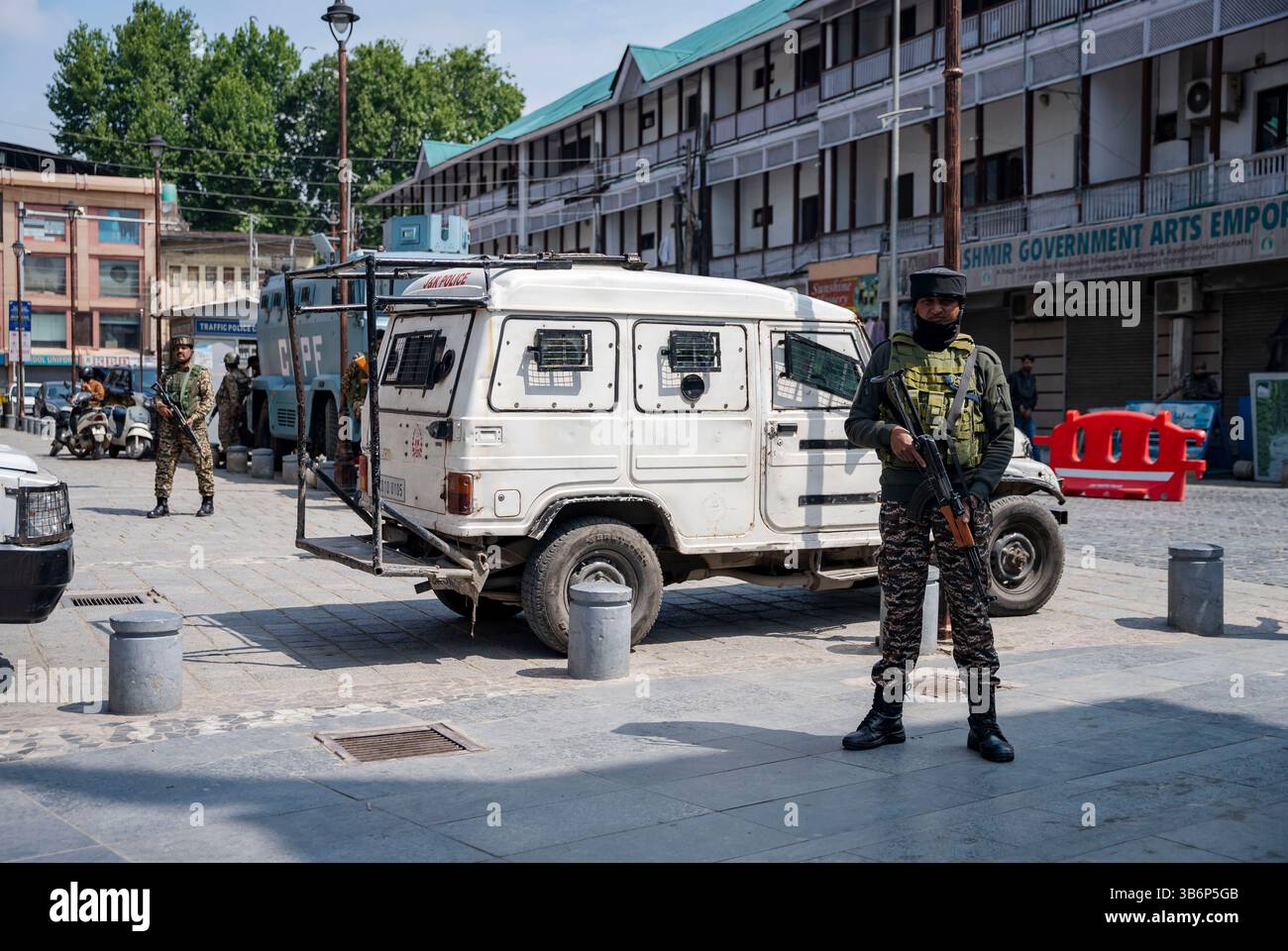 Indische Streitkräfte stehen vor einem gepanzerten Fahrzeug auf einer Straße in Srinagar Wache. Die Spannungen zwischen Indien und Pakistan haben sich nach einem militanten Angriff auf Kaschmirs Pahalgam am 22. April 2025 verschärft, bei dem 26 Tote starben und Berichten zufolge mit Pakistan in Verbindung stehen. Als Vergeltungsmaßnahme hat Indien strenge Maßnahmen ergriffen, darunter das Verbot pakistanischer Schiffe, die Aussetzung des Indus-Wasserabkommens, die Einstellung aller Importe und die Annullierung von Visa für pakistanische Staatsangehörige. Mit zunehmender Feindseligkeit droht ein begrenzter Konflikt, der die Aufmerksamkeit darauf lenkt, wie Nachbarländer wie China, Sri Lanka, Nepal, Malediven, A Stockfoto
