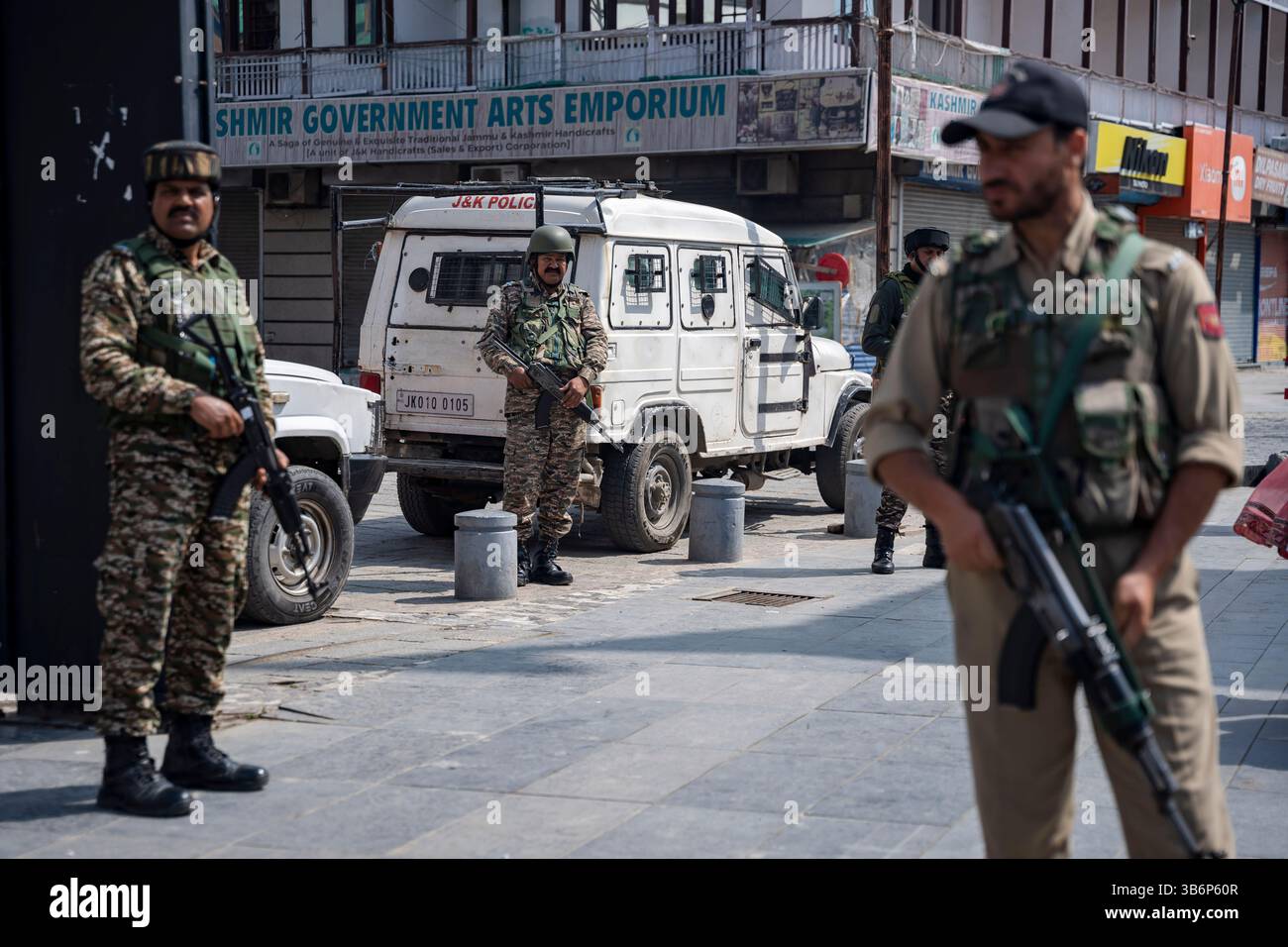 Indische Streitkräfte stehen vor einem gepanzerten Fahrzeug auf einer Straße in Srinagar Wache. Die Spannungen zwischen Indien und Pakistan haben sich nach einem militanten Angriff auf Kaschmirs Pahalgam am 22. April 2025 verschärft, bei dem 26 Tote starben und Berichten zufolge mit Pakistan in Verbindung stehen. Als Vergeltungsmaßnahme hat Indien strenge Maßnahmen ergriffen, darunter das Verbot pakistanischer Schiffe, die Aussetzung des Indus-Wasserabkommens, die Einstellung aller Importe und die Annullierung von Visa für pakistanische Staatsangehörige. Mit zunehmender Feindseligkeit droht ein begrenzter Konflikt, der die Aufmerksamkeit darauf lenkt, wie Nachbarländer wie China, Sri Lanka, Nepal, Malediven, A Stockfoto