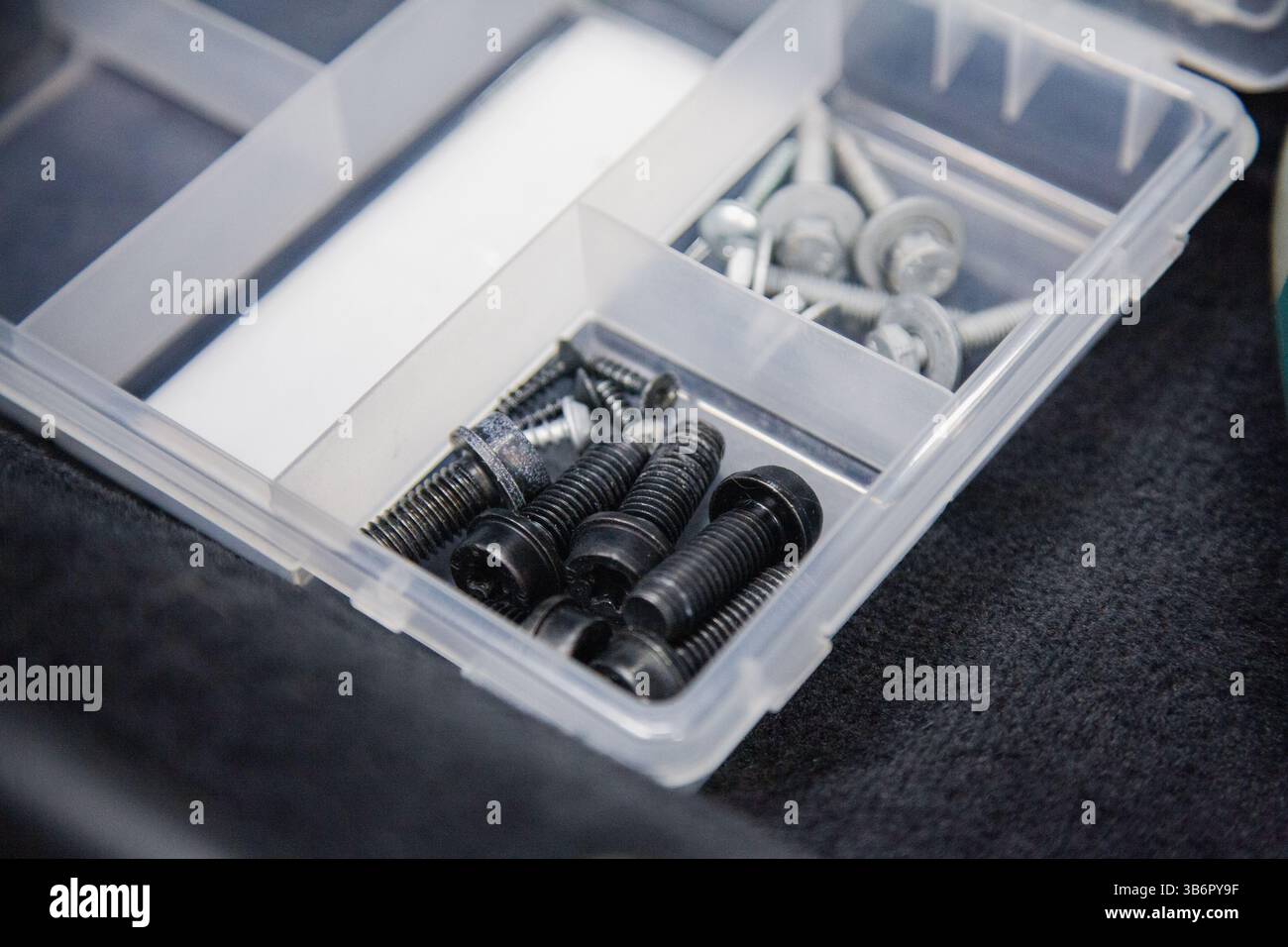 Hintergrund mit Autobolzen und Schrauben in einem Container Stockfoto