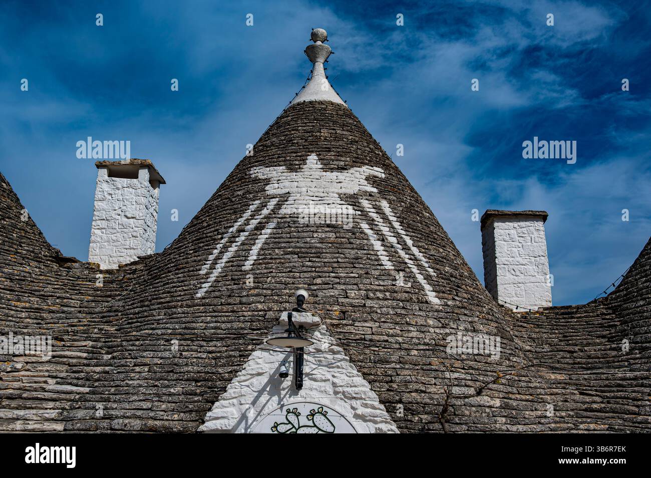 Trullo-Dach in Alberobello mit handgemalten weißen Spider-Symbolen Stockfoto