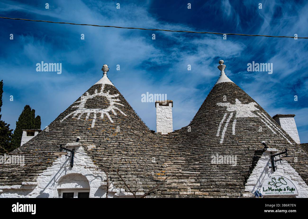 Die Dächer des siamesischen Trulli in Alberobello sind mit handgemalten weißen heidnischen Symbolen geschmückt Stockfoto