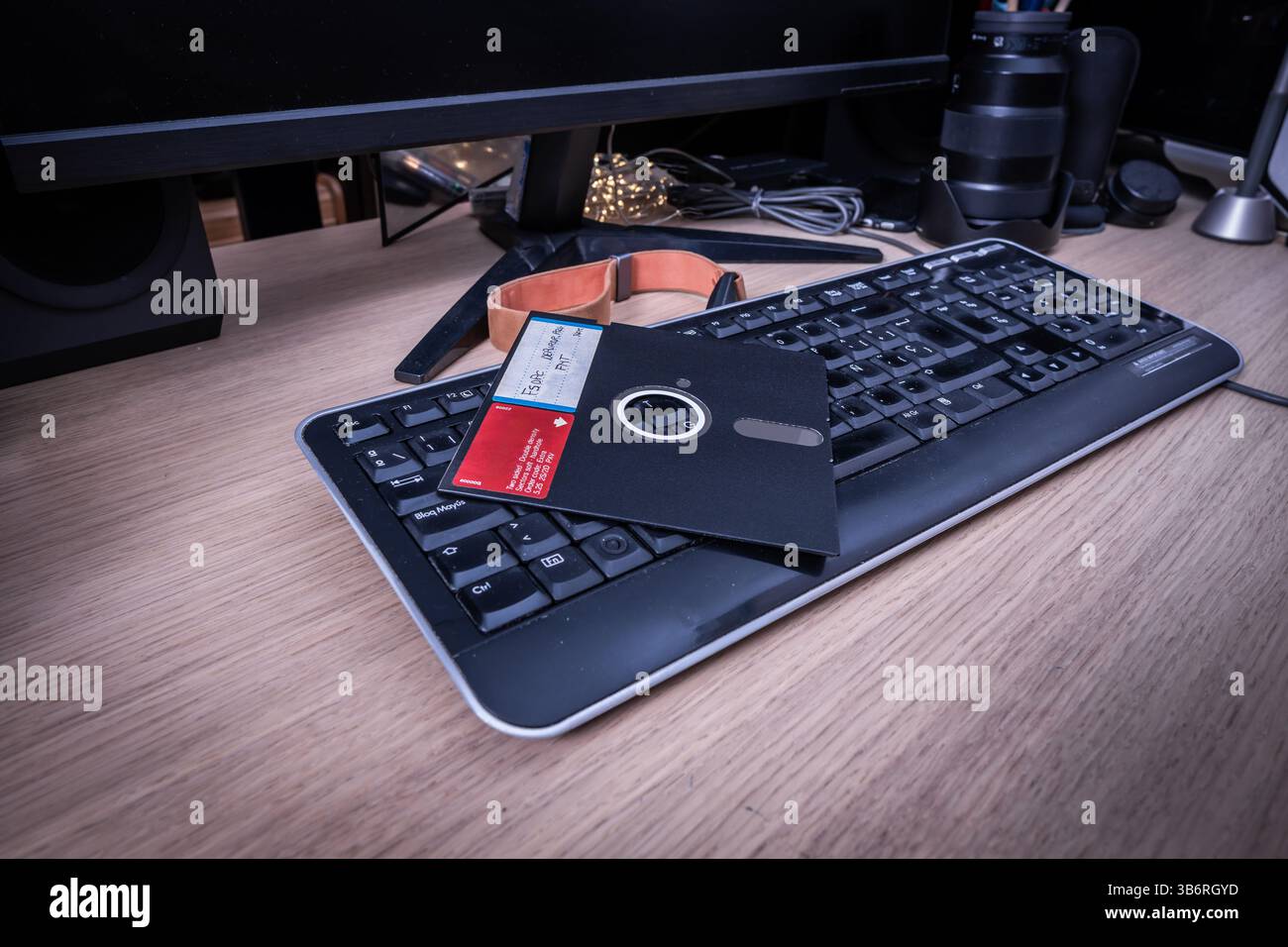 Vintage-Diskette auf einer eleganten Computertastatur, die den technologischen Fortschritt vom analogen zum digitalen Zeitalter repräsentiert Stockfoto