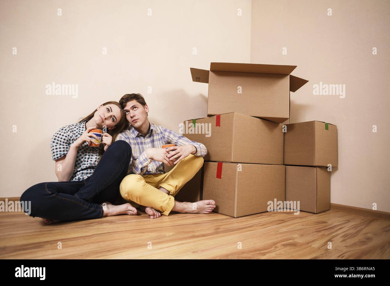Ein junges Paar mit Kisten Kaffee in der neuen Wohnung Stockfoto