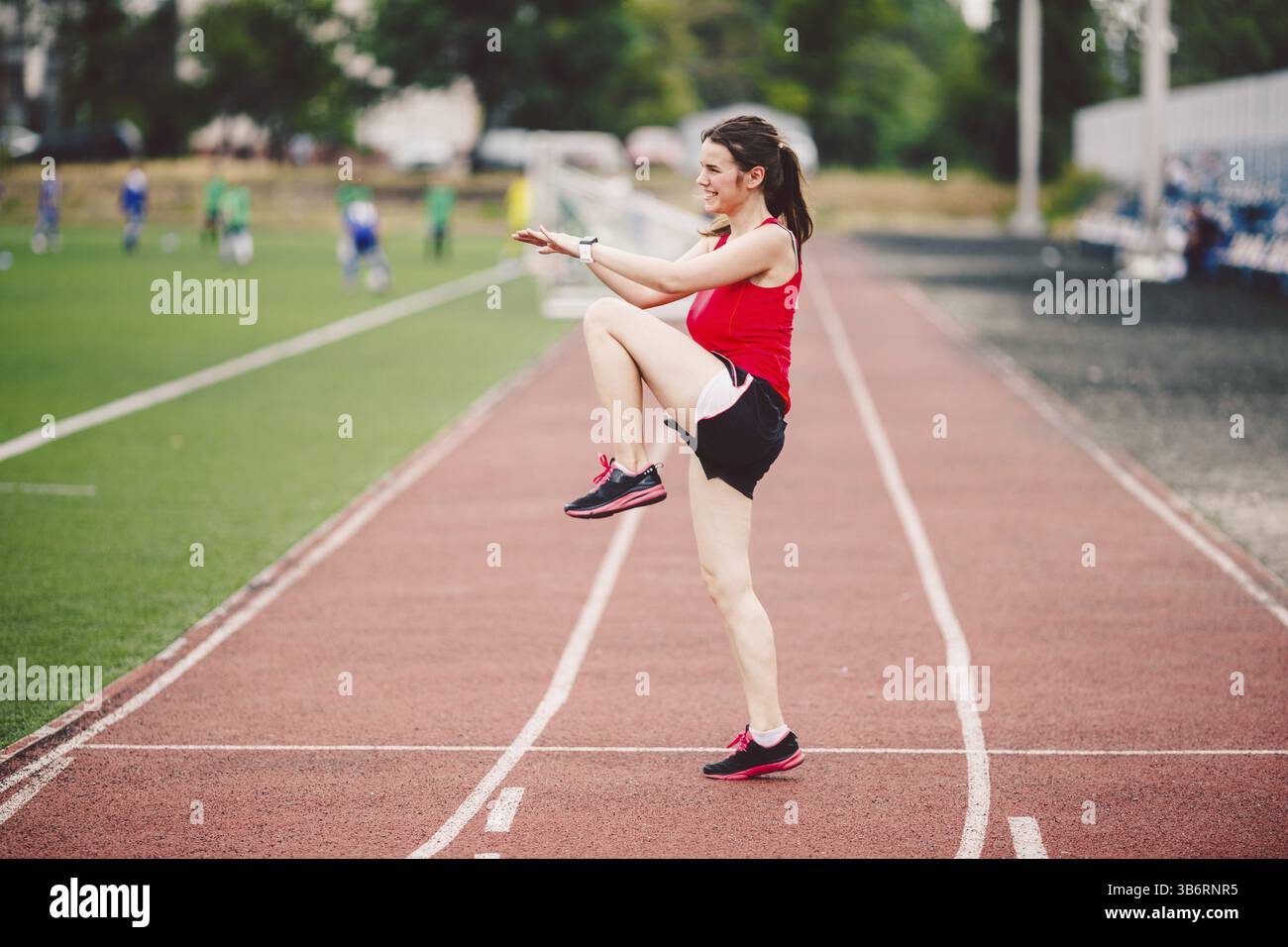 Weibliche Athletin, die die Beine für das Cardio-Training vorbereitet. Fitnesstrainer beim Aufwärmen. Läuferin wärmt sich draußen auf. Stretching und Warmin für Sportler Stockfoto