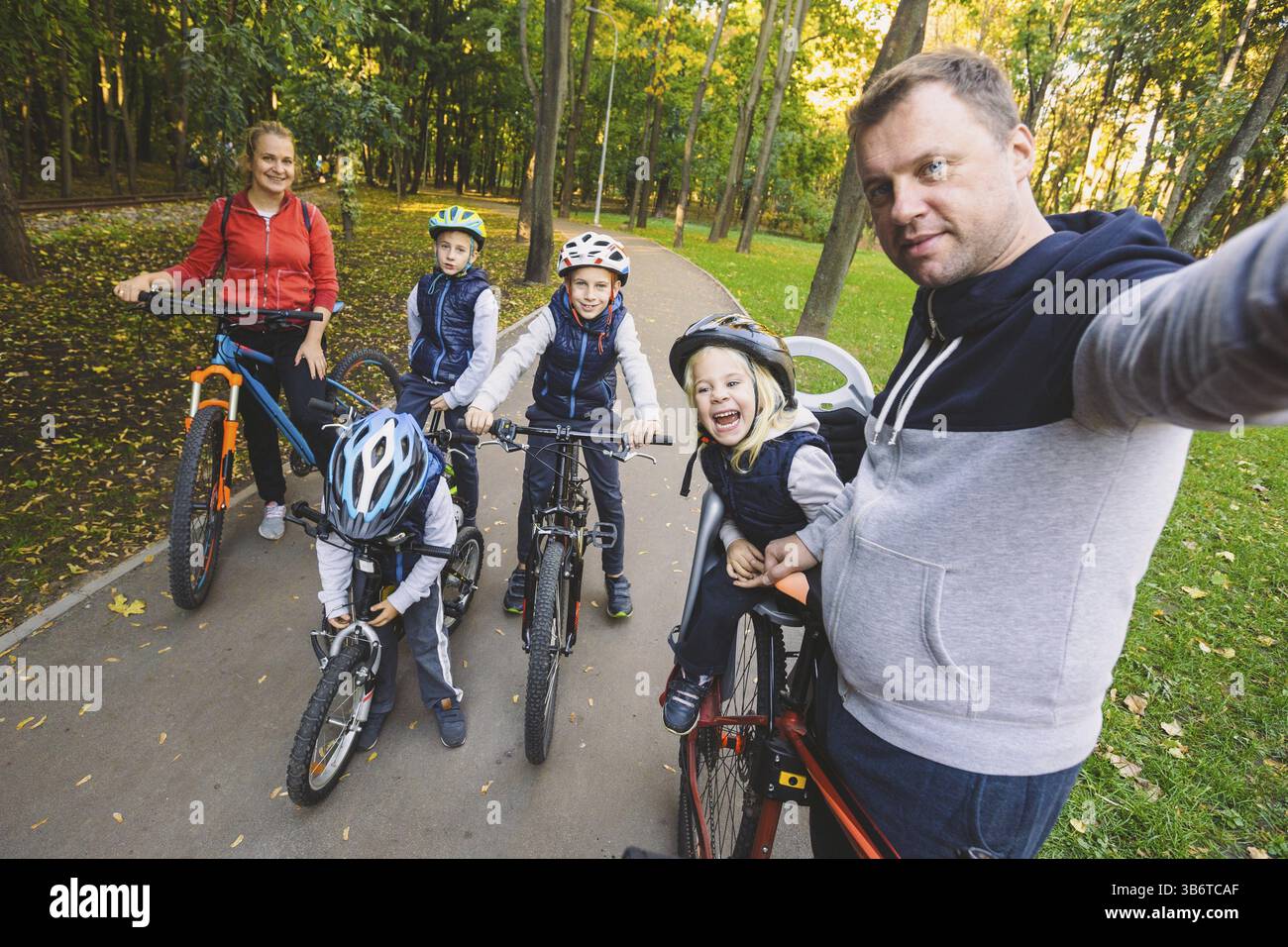 Das Thema Familie Sport Erholung im Freien. Große familie Kaukasischen 6 Personen Mama, Papa und 4 Kinder drei Brüder und Schwester fahren Fahrräder im Park auf Stockfoto