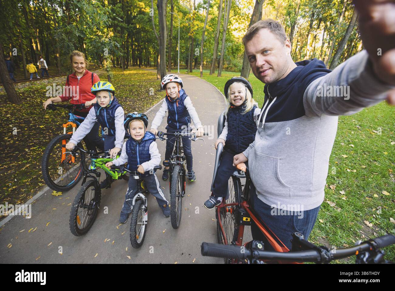 Das Thema Familie Sport Erholung im Freien. Große familie Kaukasischen 6 Personen Mama, Papa und 4 Kinder drei Brüder und Schwester fahren Fahrräder im Park auf Stockfoto