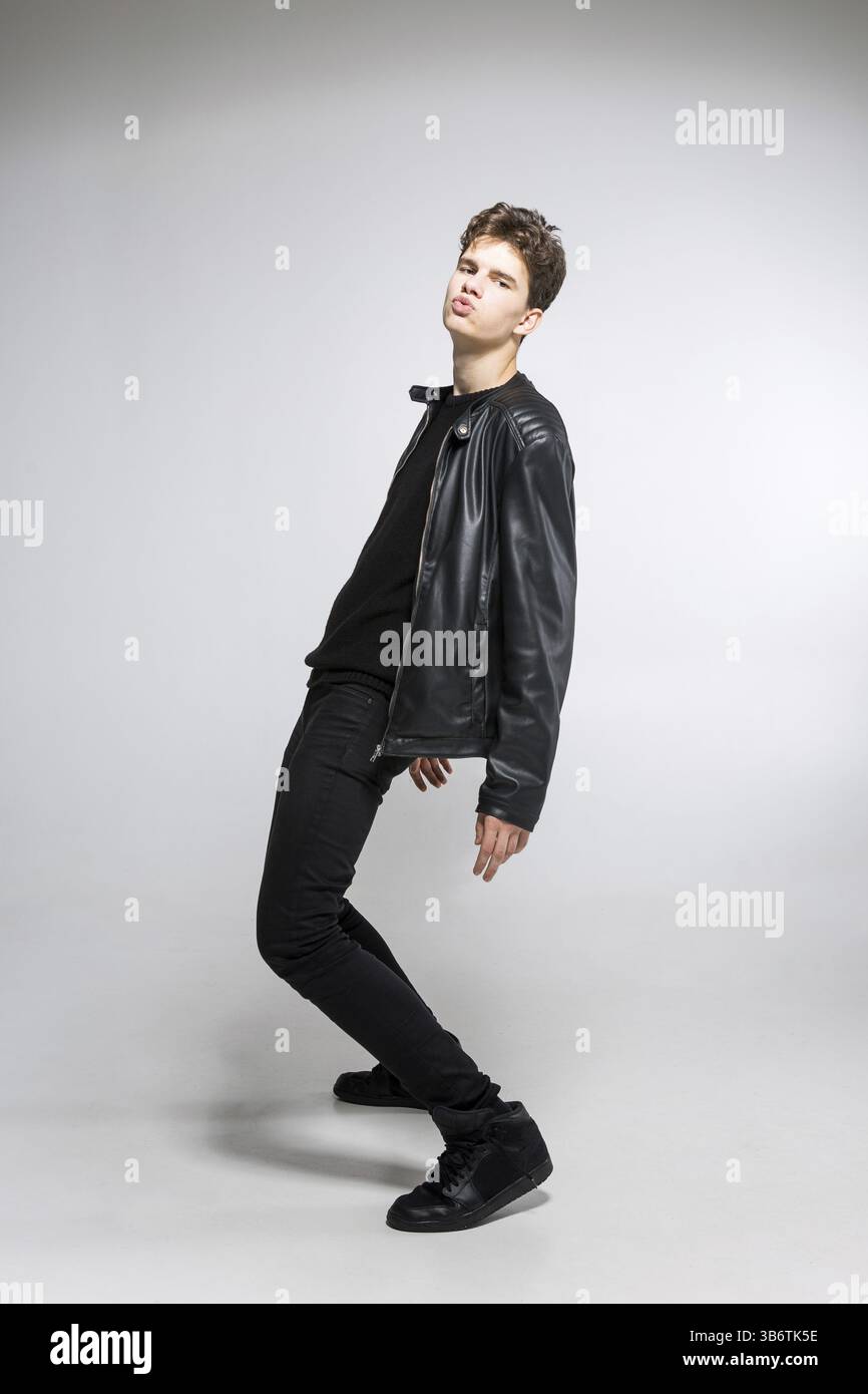 Ganzes-Porträt eines jungen fitten Mannes in dunklen Tüchern auf weißem Hintergrund. Junge Männliche Models Posieren In Lässigem Outfit. Attraktives junges Fashi Stockfoto