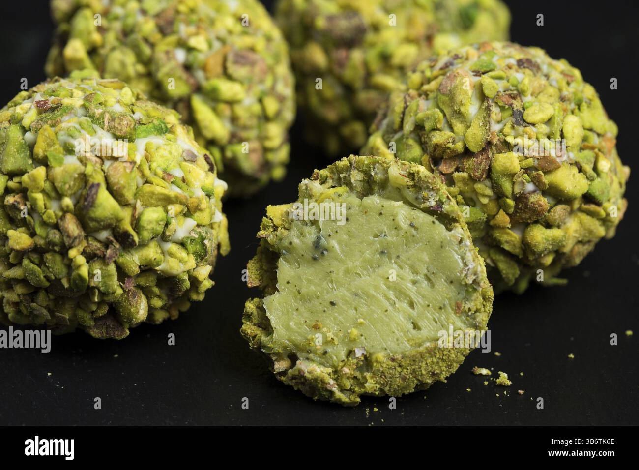 Thema süße Nachspeise Kuchen handgefertigt. Makro close-up Dessert Desserts Süßigkeiten runde Kugel weiße Trüffel ball Set von weißer Schokolade, Matcha Tee und Pis Stockfoto