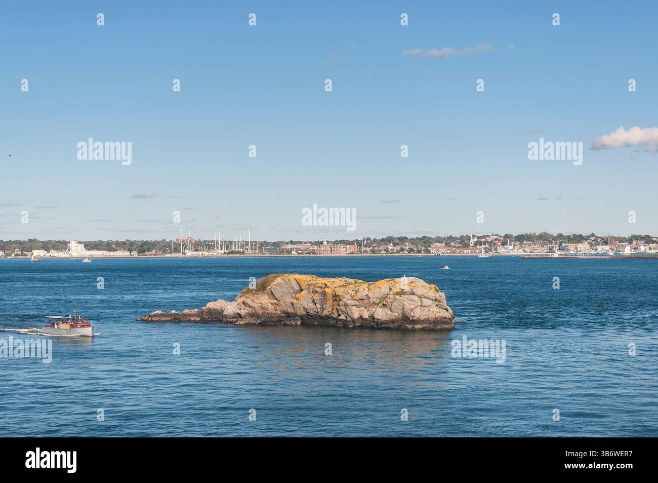 Ein kleines Boot, das auf einem großen Felsen in der Nähe des Fort Wetherill State Parks in Jamestown Rhode Island fährt Stockfoto