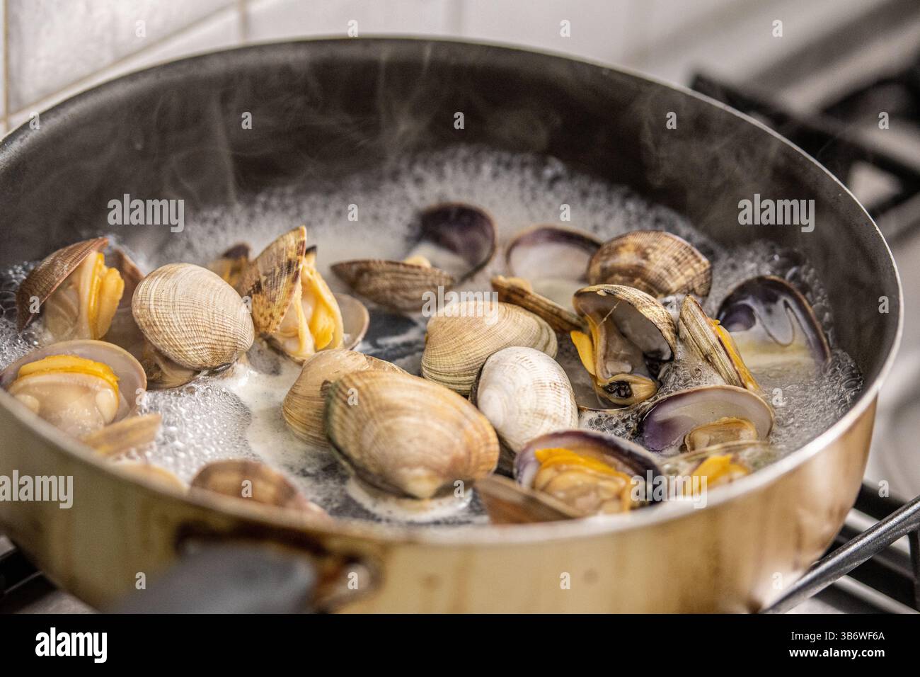 Muscheln in kochendem Wasser in einer Pfanne auf dem Herd kochen, Spaghetti oder Linguine mit Muscheln zubereiten, Nahaufnahme Stockfoto