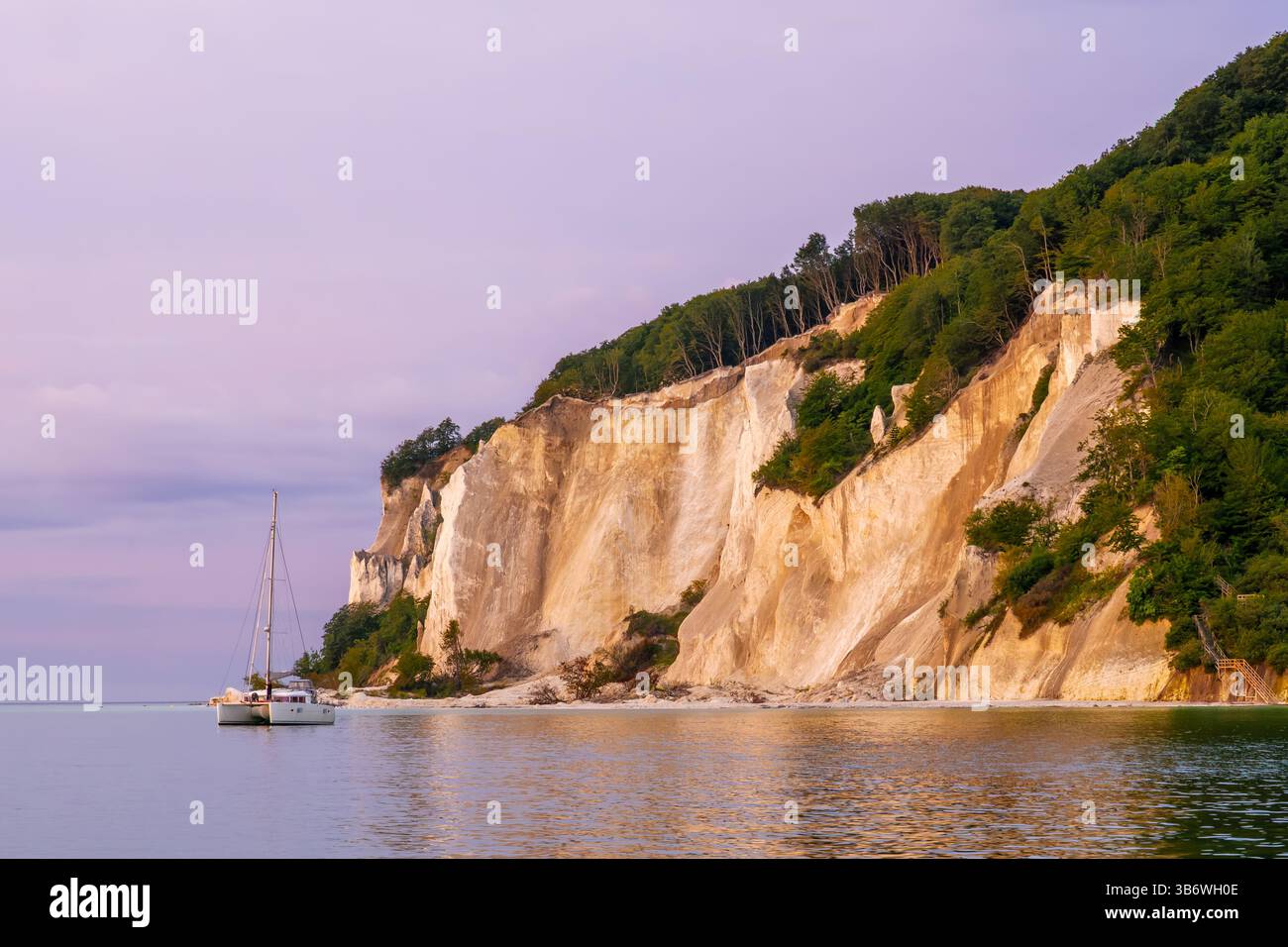 Katamaran-Segelboot vor Anker in der Nähe der Kreidefelsen von Møn während des frühen MorgenSonnenaufgangs, Ostsee, Neuseeland, Dänemark, malerische Küstenlandschaft Stockfoto