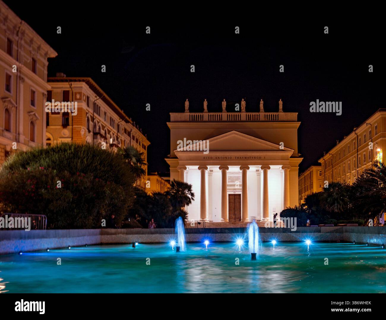 Nächtlicher Blick auf ein großes Gebäude mit klassischer Architektur, mit einem Brunnen im Vordergrund. Die Szene wird beleuchtet und hebt das A hervor Stockfoto