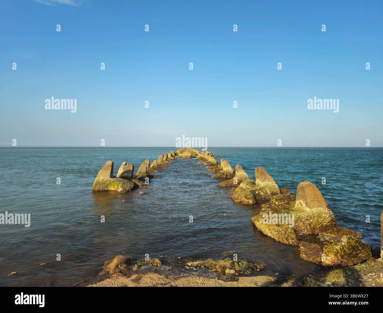 Verlassene erodierte Küstenstraße, die ins Meer führt Stockfoto