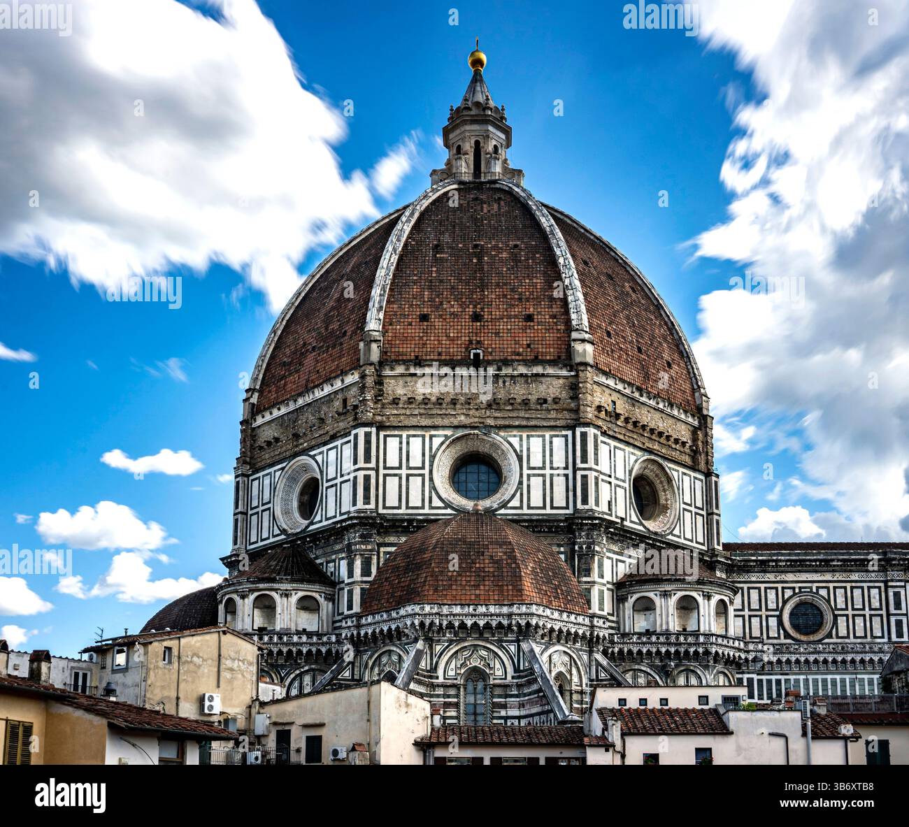 Ein atemberaubender Blick auf eine historische Kathedrale mit einer großen Kuppel unter einem hellblauen Himmel voller flauschiger Wolken. Die komplizierten architektonischen Details und s Stockfoto