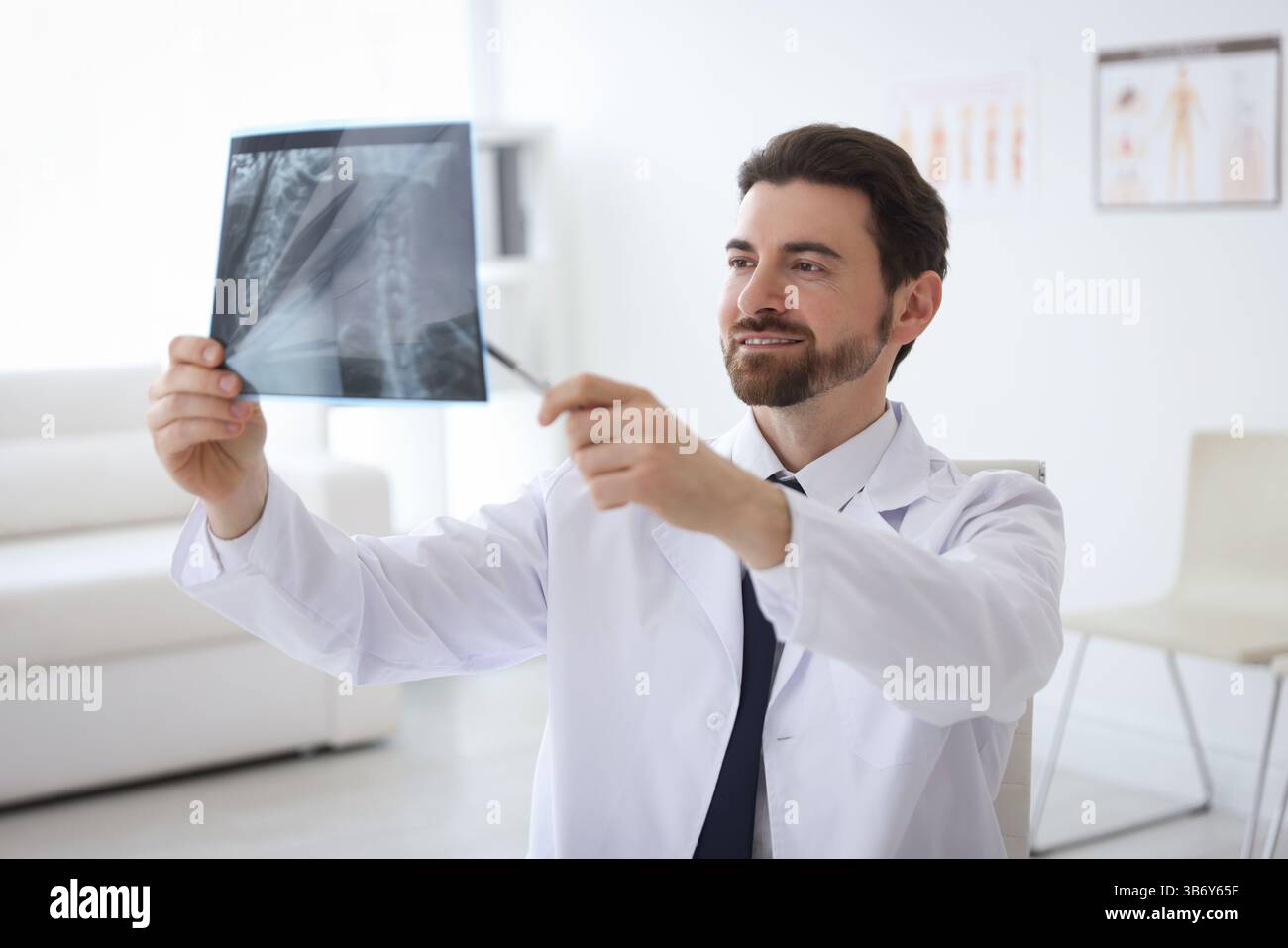 Lächelnder Arzt untersucht Hals-MRT in der Klinik Stockfoto