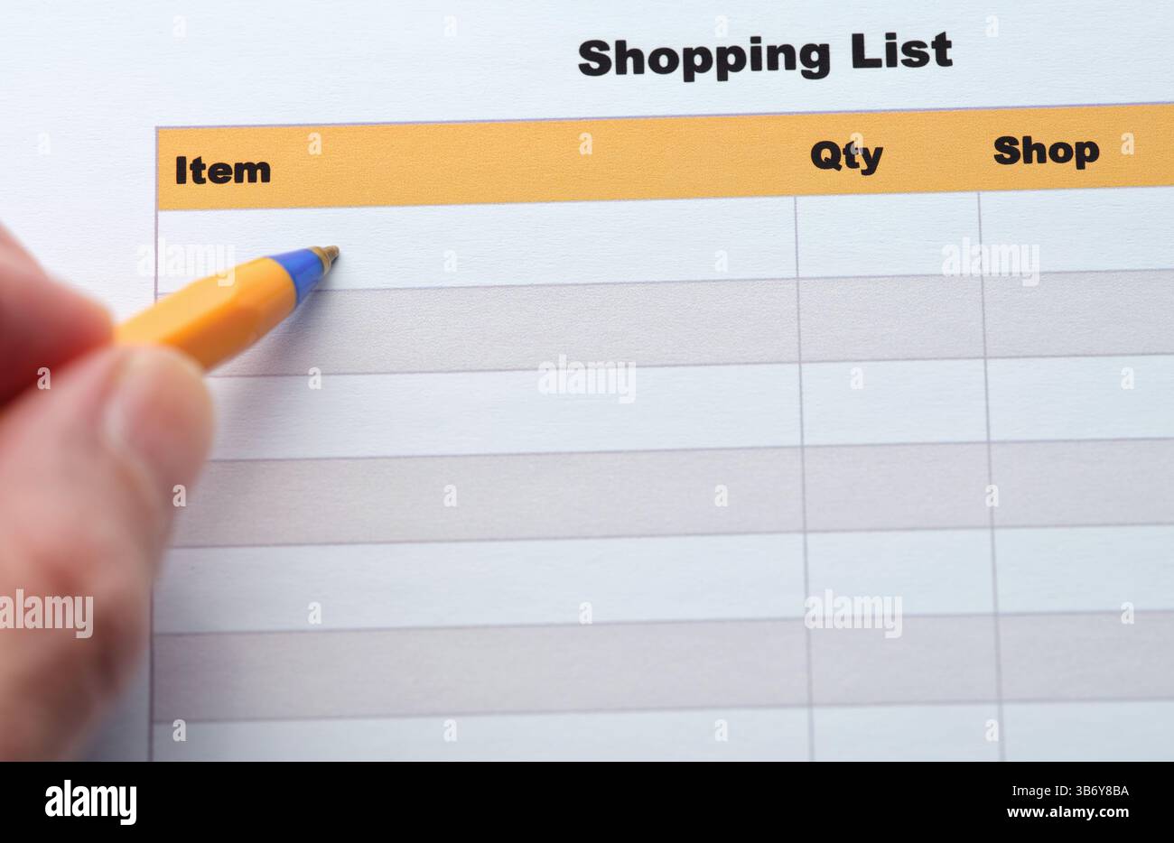Ein Mann, der eine Einkaufsliste mit einem Kugelschreiber ausfüllt. Nahaufnahme. Stockfoto