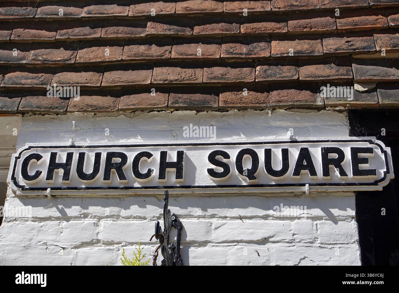 Traditionelles Straßenschild am Church Square an einer weiß getünchten Wand in einem historischen englischen Dorf, unter hellem Tageslicht erfasst. Rye, Sussex, England Stockfoto