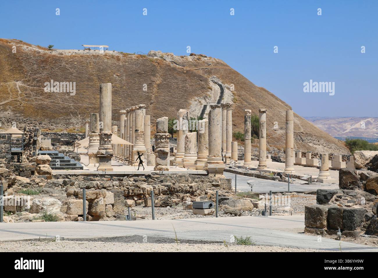 Panoramablick auf die römische Säulenstraße im Beit She’an Nationalpark, Israel, mit gut erhaltenen Säulen und einem Hügel im Hintergrund. Stockfoto