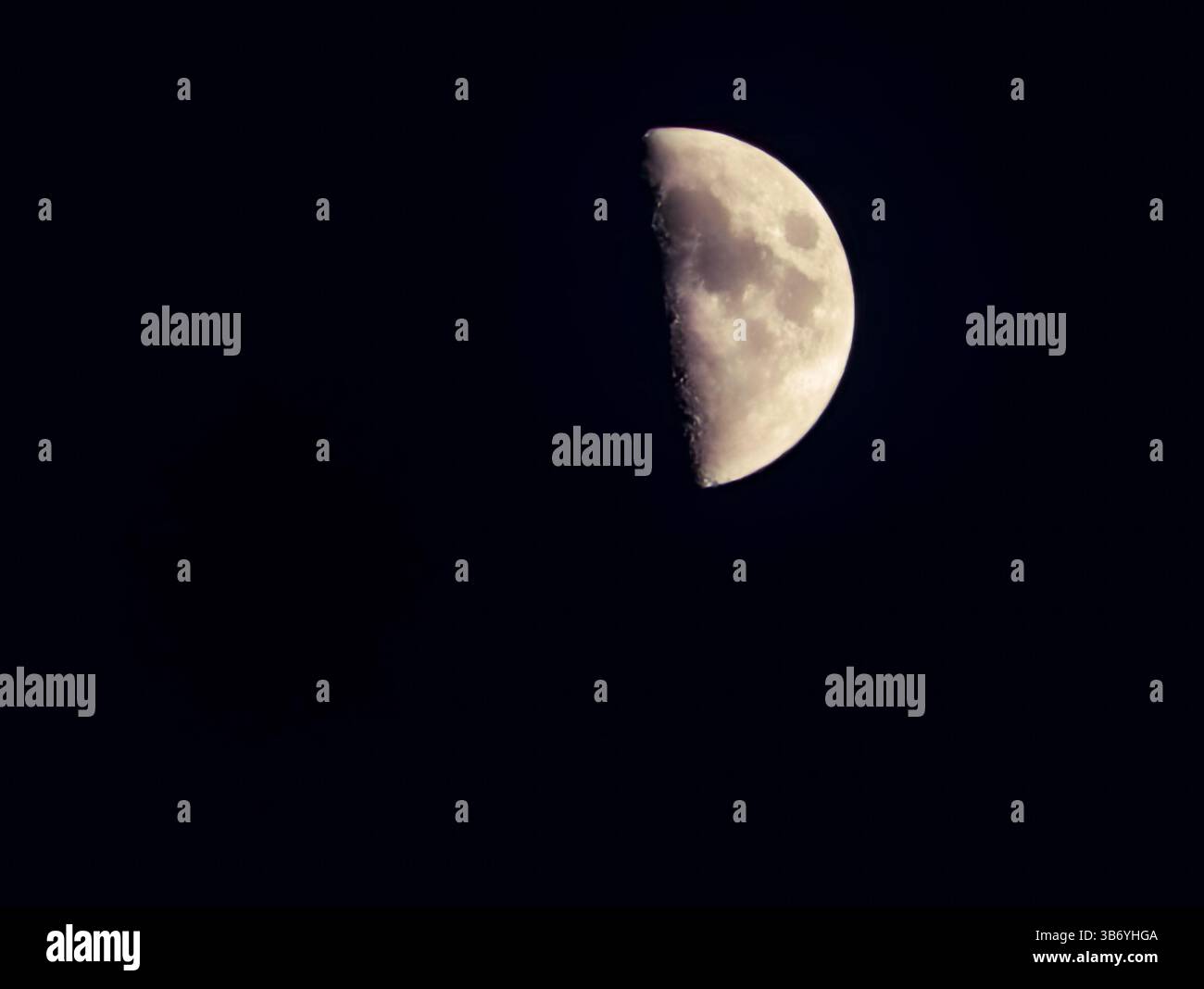 Halbmond im Nachthimmel. Detailliertes Thema Mondoberfläche, Astronomie und Weltraumforschung, Himmelskörper in der Dunkelheit, ruhige Weltraumszene Stockfoto