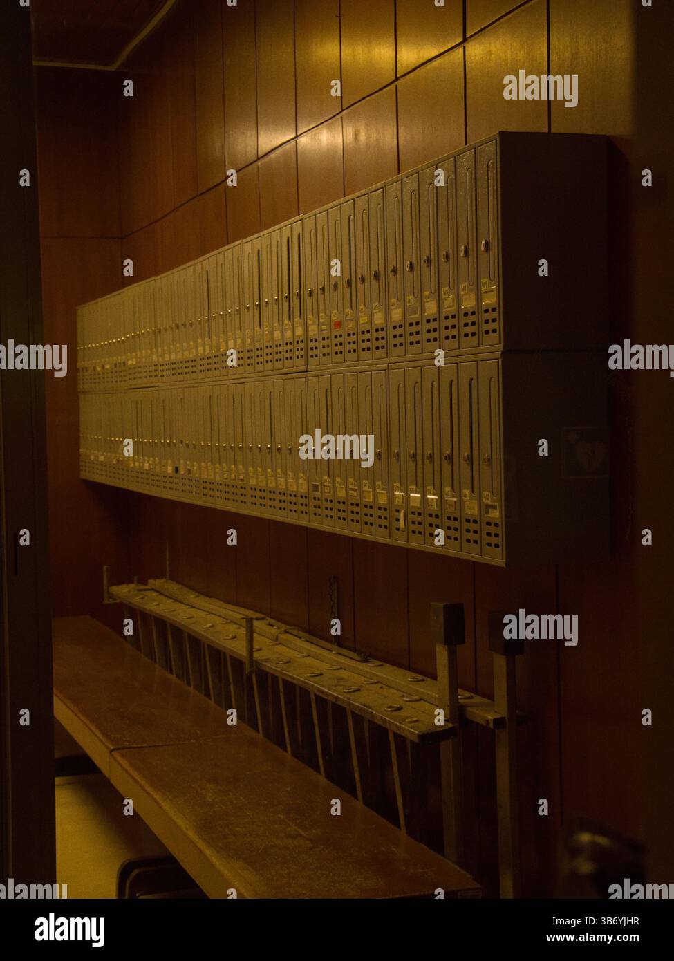 Reihe von Postfächern im schwach beleuchteten Holzeingang Stockfoto