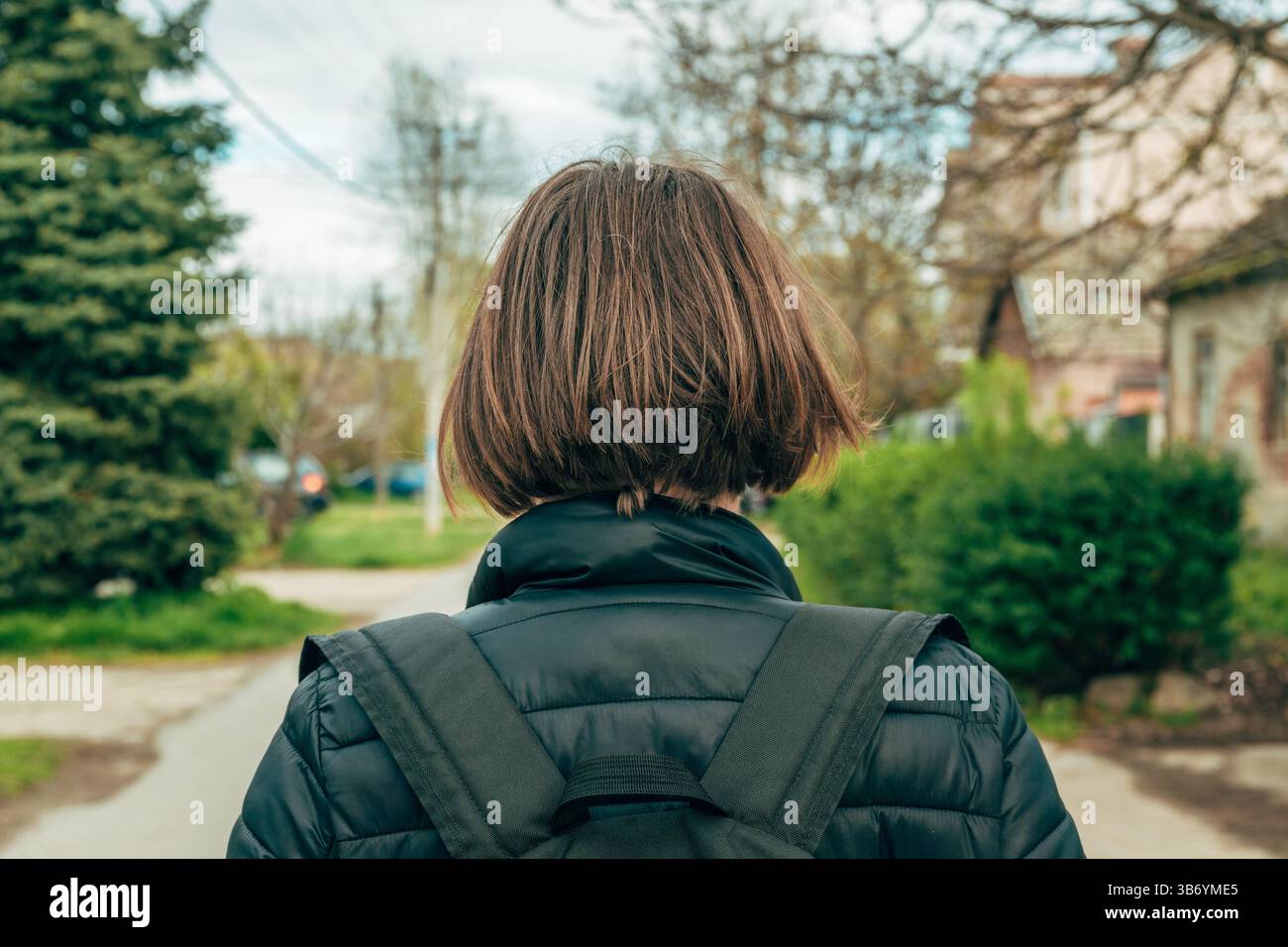 Weibliche Fußgängerin, die auf der Straße läuft, Rückansicht Stockfoto