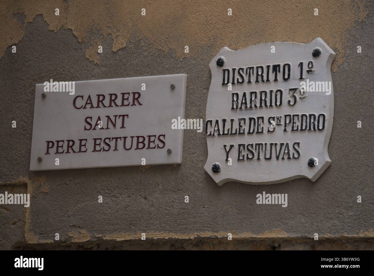 Historische zweisprachige Straßenschilder „Carrer Sant Pere Estubes“ und „Calle de San Pedro y Estuvas“ an einer Mauer in Tarragonas Altstadt, Spanien.Salou, Spanien Stockfoto