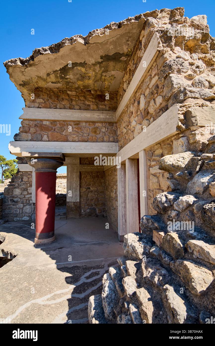 Die Überreste des Knossos Palace zeigen eine beeindruckende rote Säule und ein altes Mauerwerk. Diese Aussicht unterstreicht die architektonische Brillanz des minoischen c Stockfoto