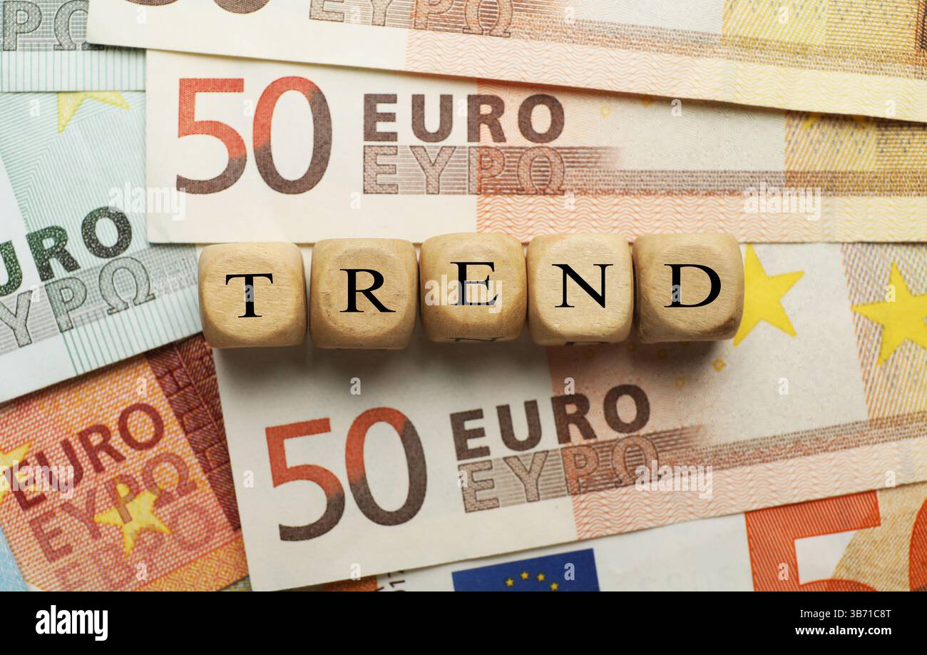Word Trend aus Holzwürfeln mit Buchstaben auf Euroscheine, Draufsicht Stockfoto