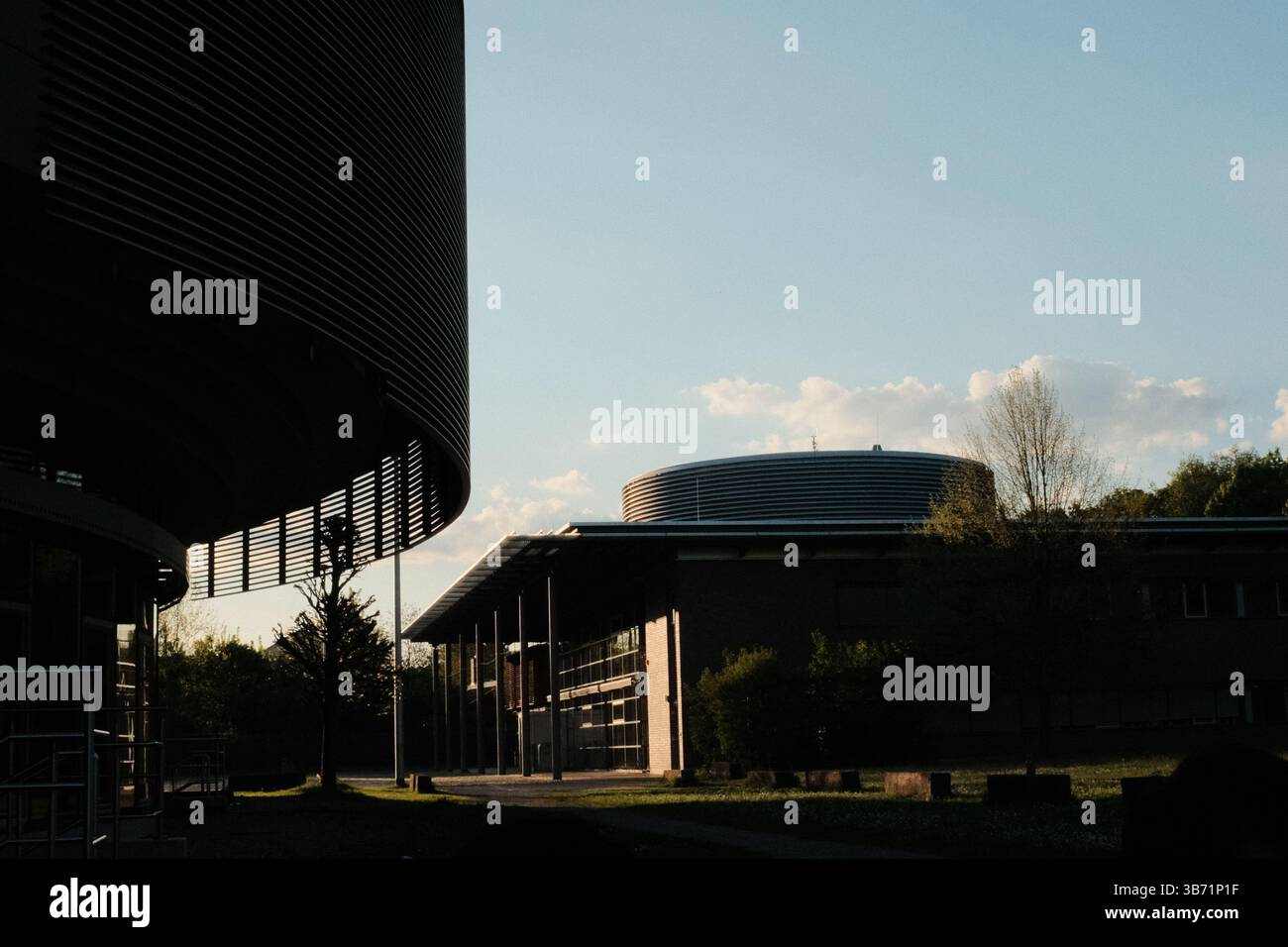Moderne Wohn- und Institutionengebäude unter klarem blauem Himmel mit Bäumen und Schatten im Frühlingssonnenlicht. Hochwertige Fotos Stockfoto