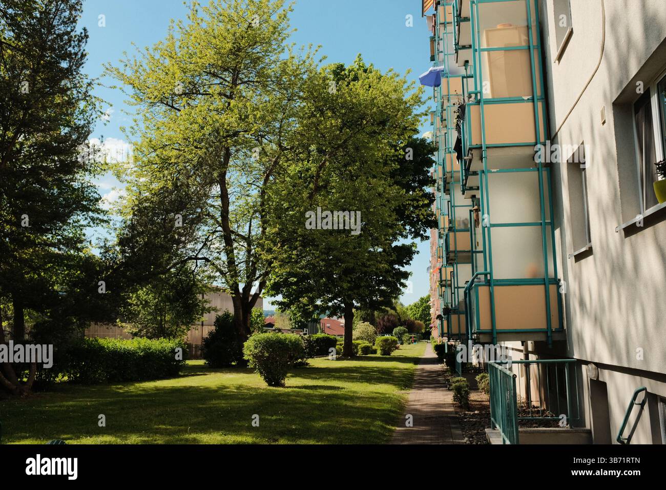 Moderne Wohn- und Institutionengebäude unter klarem blauem Himmel mit Bäumen und Schatten im Frühlingssonnenlicht. Hochwertige Fotos Stockfoto