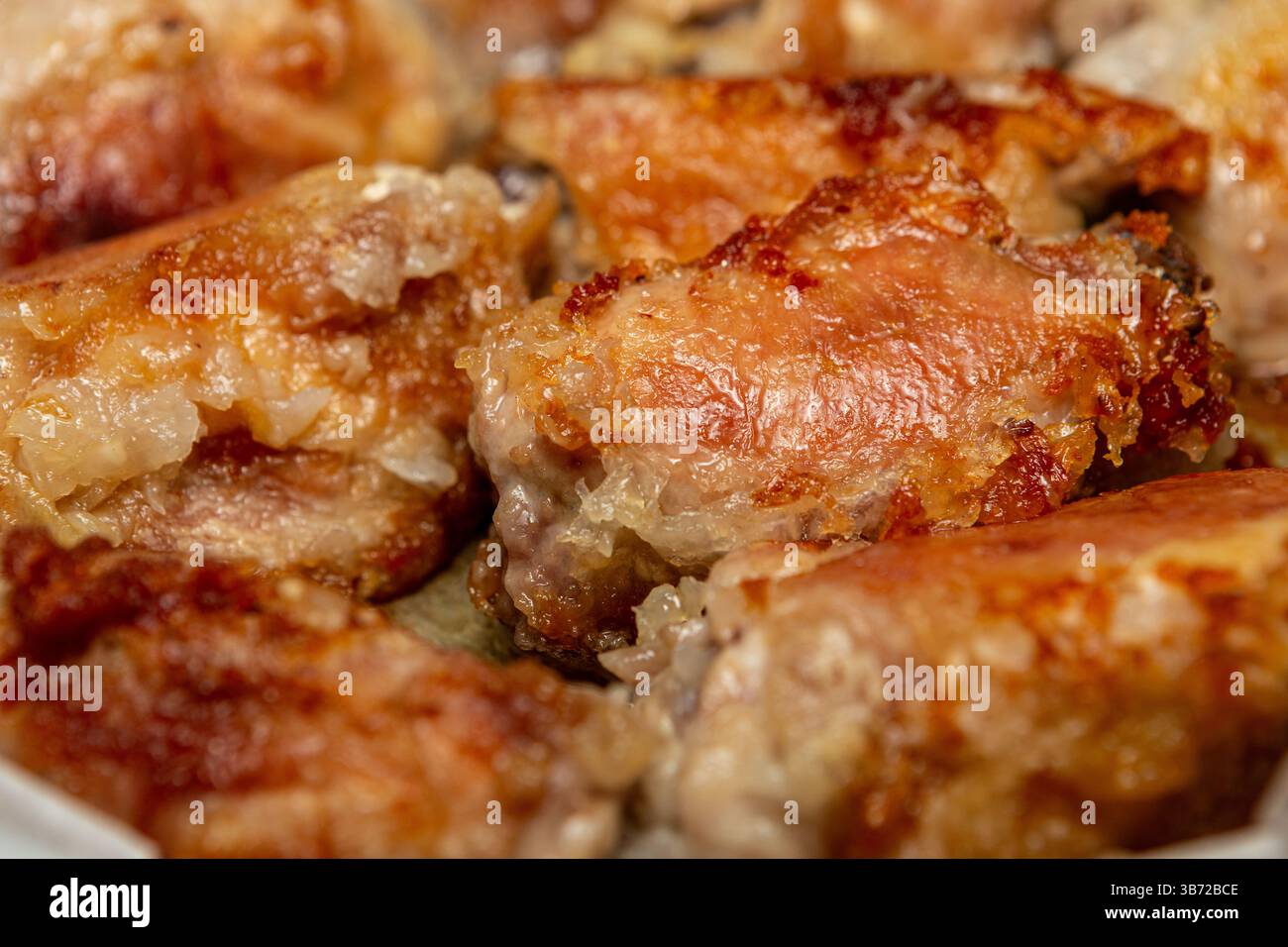 Nahaufnahme von perfekt gebratenen Hähnchenschenkeln mit tiefgoldbrauner Kruste. Stockfoto