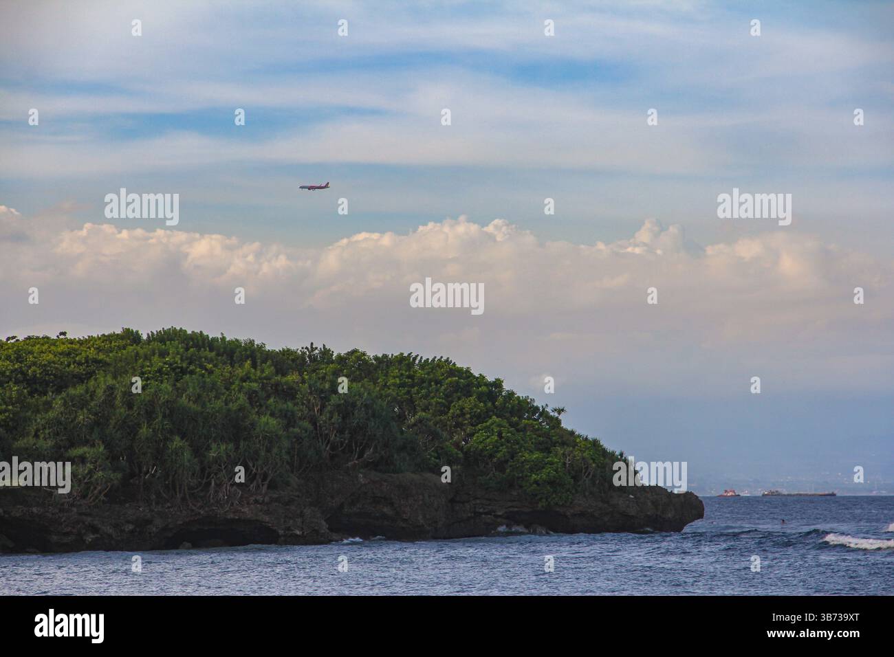 Ein Flugzeug fliegt über eine dichte, mit Mangroven bedeckte Insel nahe der Küste Balis, ein Naturschutzgebiet für Öko-Tourismus und Küstenforschung. Stockfoto