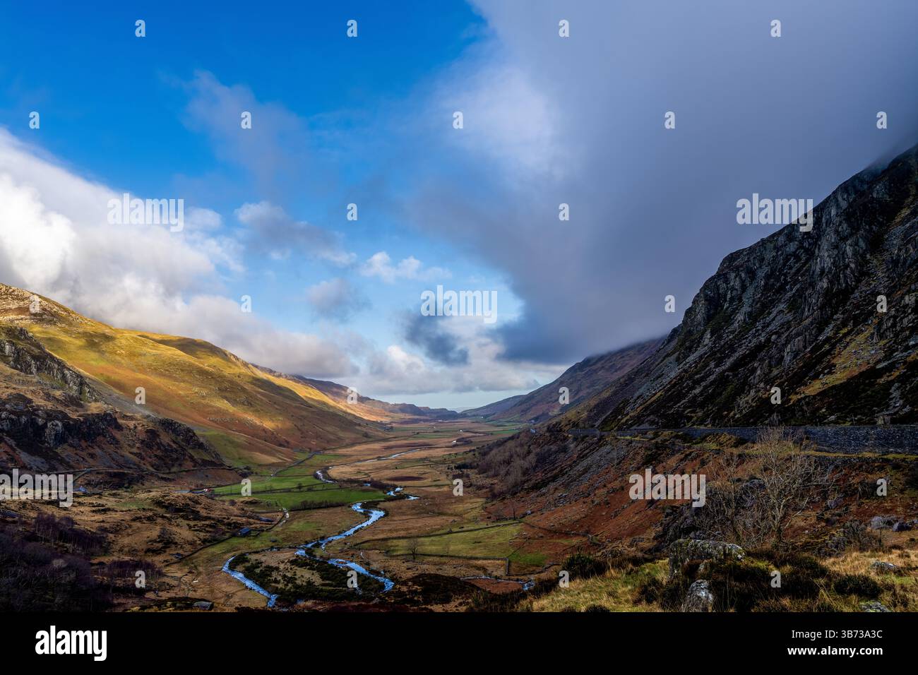 Der Afon Ogwen schlängelt sich durch das heidekraute Gletschertal unter einem dynamischen Snowdonia-Himmel Stockfoto