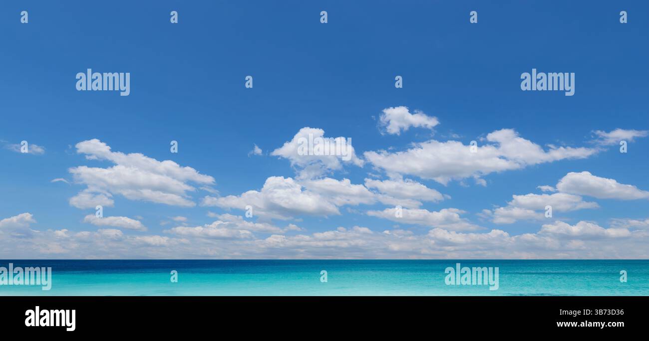 Wunderschöne Meereslandschaft mit einer riesigen Fläche von türkisfarbenem Wasser unter einem leuchtend blauen Himmel mit flauschigen weißen Wolken Stockfoto