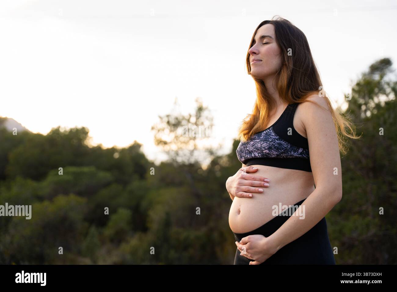 Schwangere Frau in der Natur, die Ruhe und Wohlbefinden genießt Stockfoto